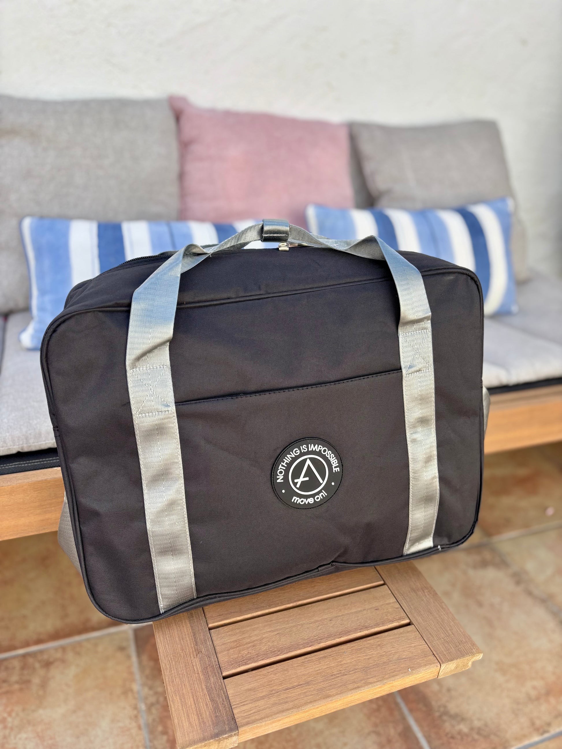 Detalle del estampado frontal con frase “Nothing is Impossible – Move On” en bolsa de viaje moderna