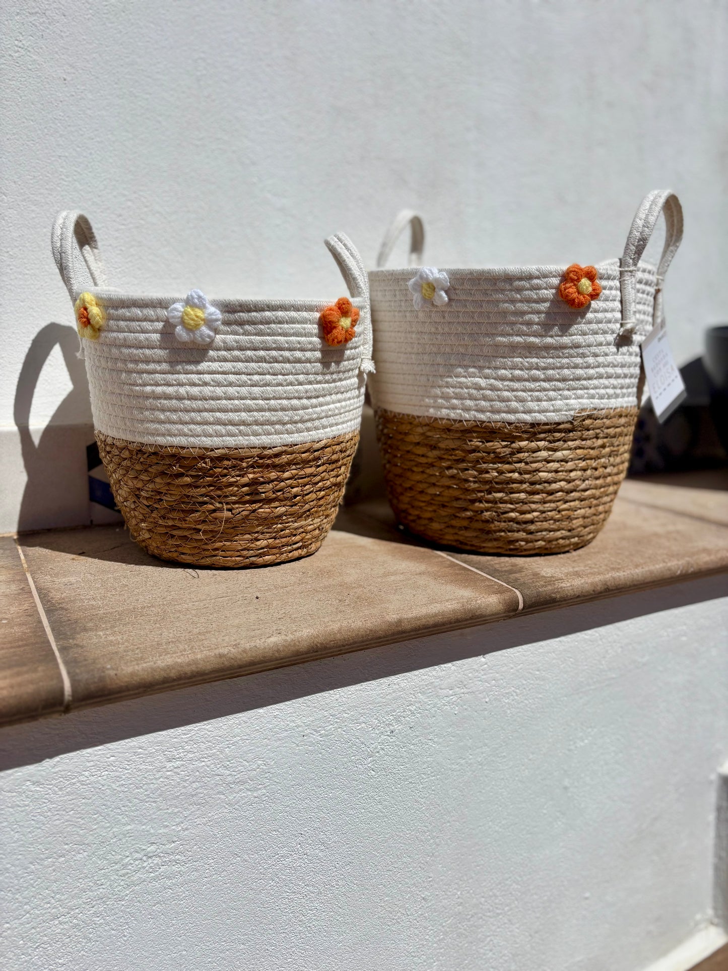 Pack de cestos de mimbre natural y algodón blanco con asas laterales y detalle floral decorativo, tamaño grande