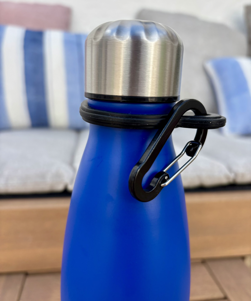 Detalle de botella térmica con mosquetón incorporado para fácil transporte, diseño práctico y funcional