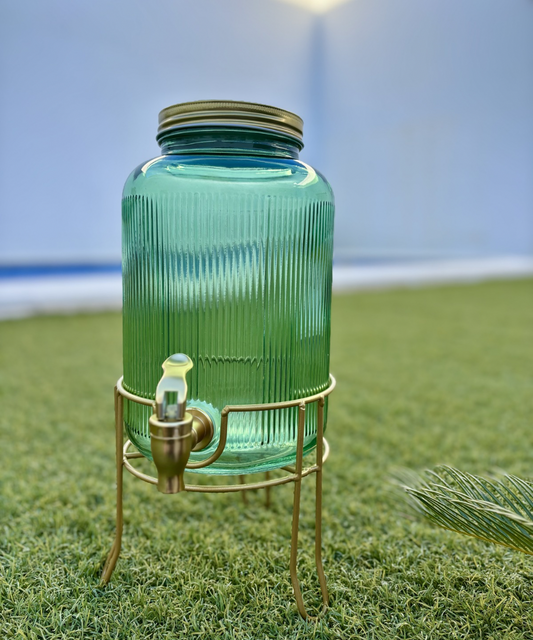 Dispensador de bebidas Emerald Gold de vidrio verde esmeralda con soporte dorado, ideal para servir limonada, agua o zumos en reuniones y eventos