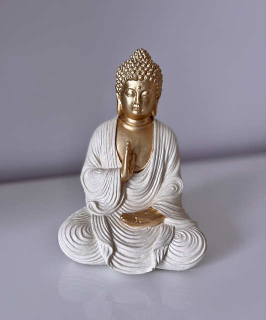 Figura decorativa Buda Priya meditando en resina con acabado blanco y dorado, ideal para crear ambientes zen en salón o estantería