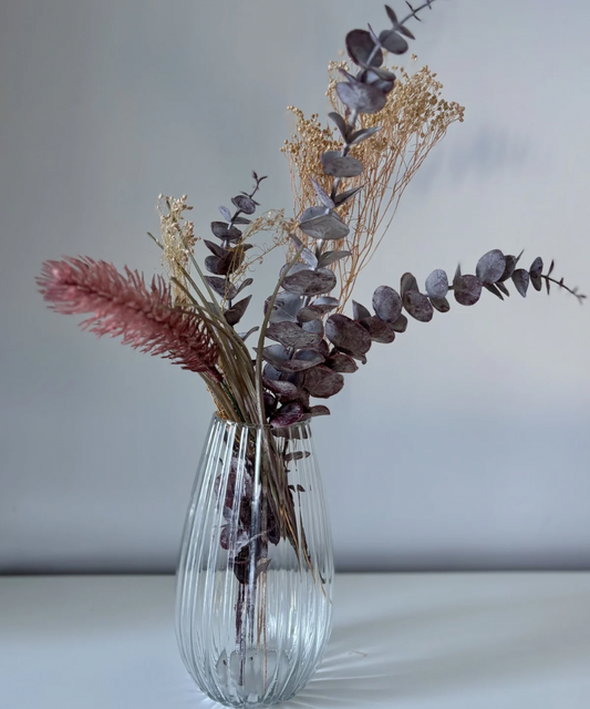 Jarrón de vidrio transparente acanalado en ambiente decorativo con flores preservadas, estilo moderno para salón o centro de mesa