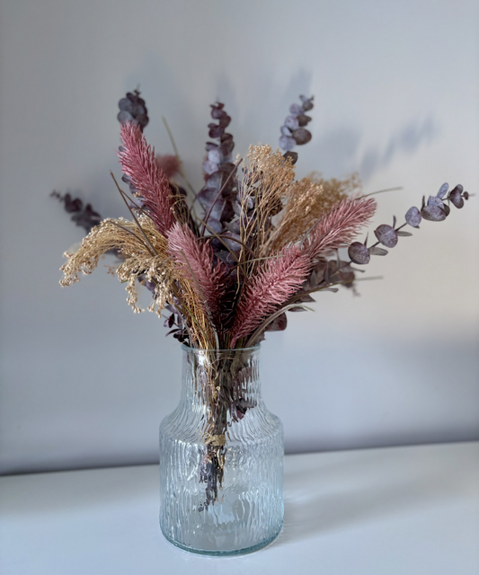 Jarrón de vidrio texturizado en tono verdoso con flores decorativas, diseño moderno y natural ideal para decoración del hogar