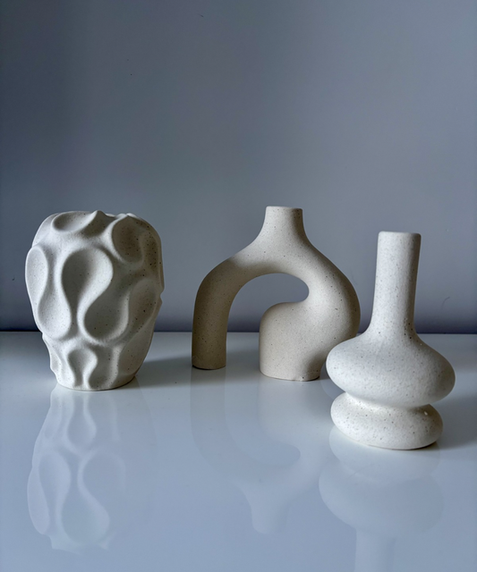 Set de jarrones decorativos de cerámica en tonos blancos con diseños escultóricos modernos, ideal para decoración de salón o estanterías