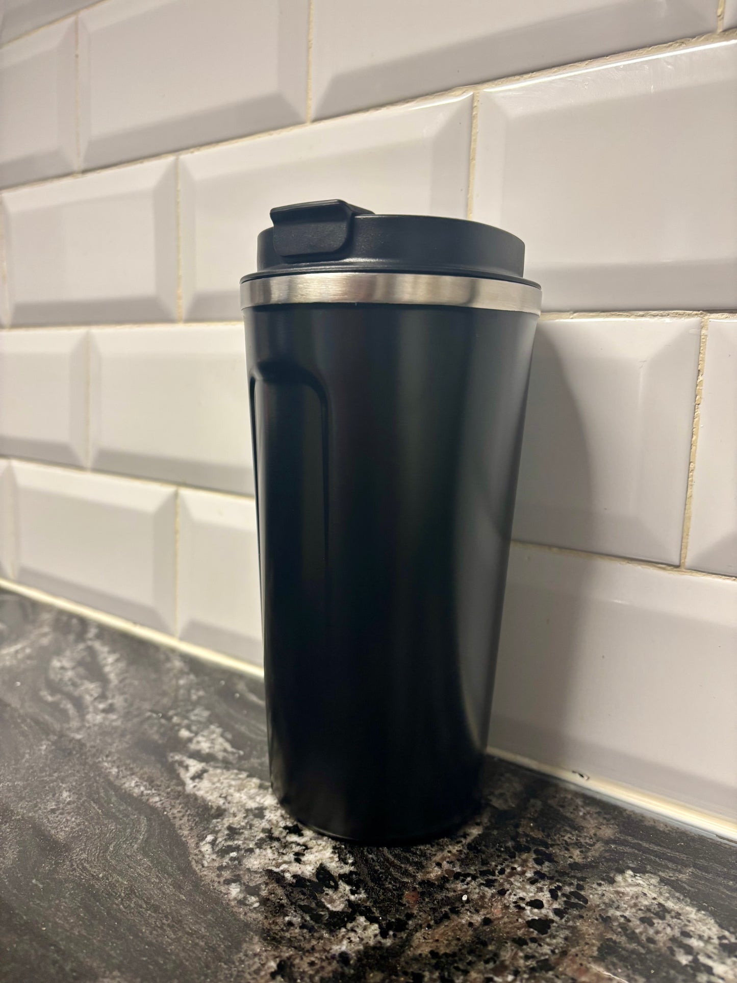 Vaso térmico negro con tapa negra y apertura para beber, ideal para café y bebidas calientes