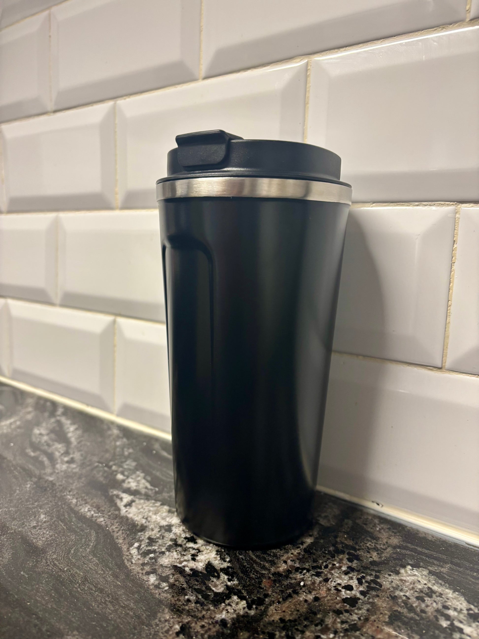 Vaso térmico negro con tapa negra y apertura para beber, ideal para café y bebidas calientes